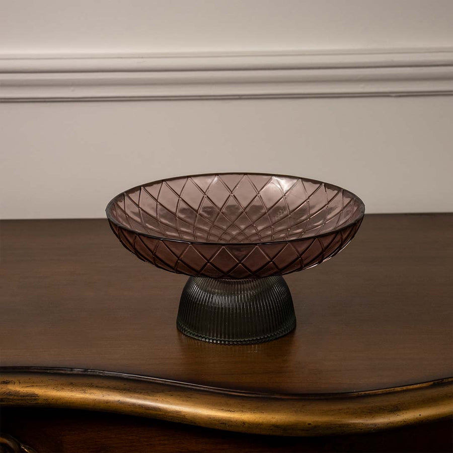 Modern smoky brown glass bowl with criss-cross embossed pattern and dark ribbed pedestal base on a plain white backdrop.