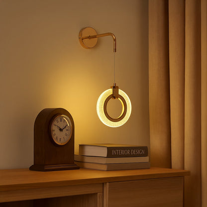 Wall mounted ring light in metal finish glowing warmly above console table adding ambient lighting and modern decor to cozy living space.
