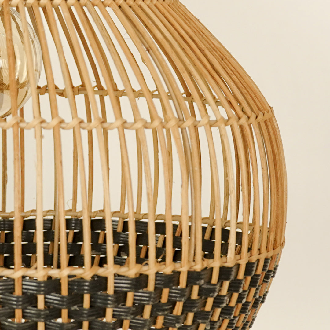 Natural and black rattan pendant light closeup highlighting intricate weave and artisanal craftsmanship.