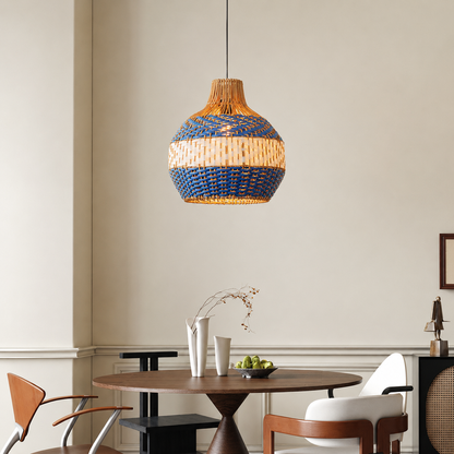 A woven pendant light with a blue and natural beige striped pattern hangs over a round wooden dining table in a modern, neutral-toned dining room.