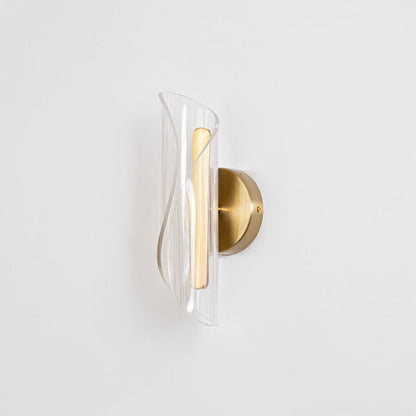 Gold wall light with sculpted clear glass shade shown on a bright white background with lights off for clarity.