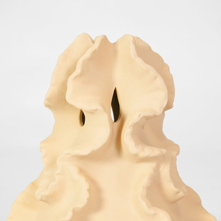 Closeup image of beige ceramic artistic sculpture for modern tabletop decor styling with elegant textured matte finish.