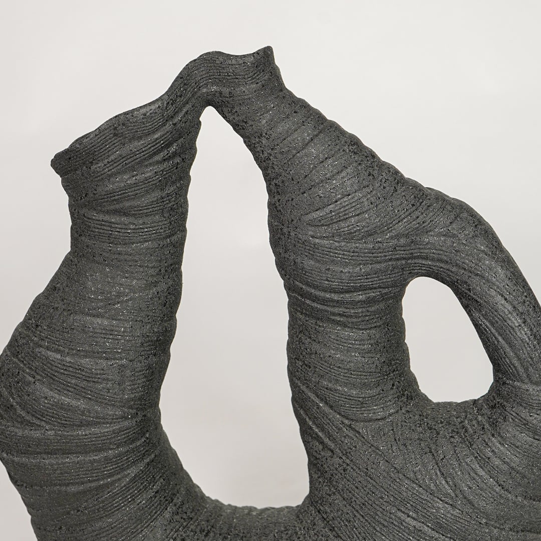 Detailed view of textured black abstract ceramic vase for modern artistic home decor and creative shelf styling.