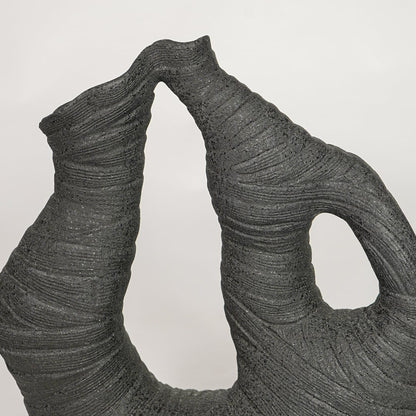 Detailed view of textured black abstract ceramic vase for modern artistic home decor and creative shelf styling.