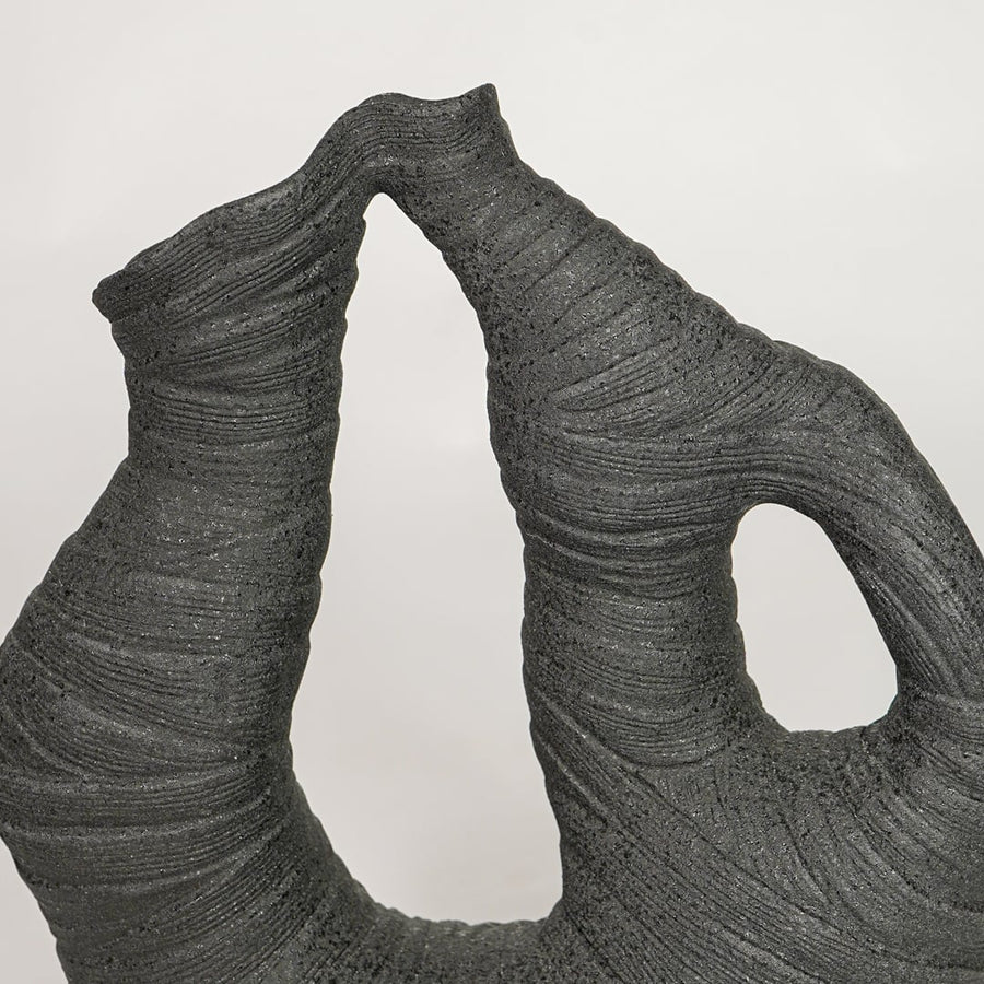 Detailed view of textured black abstract ceramic vase for modern artistic home decor and creative shelf styling.