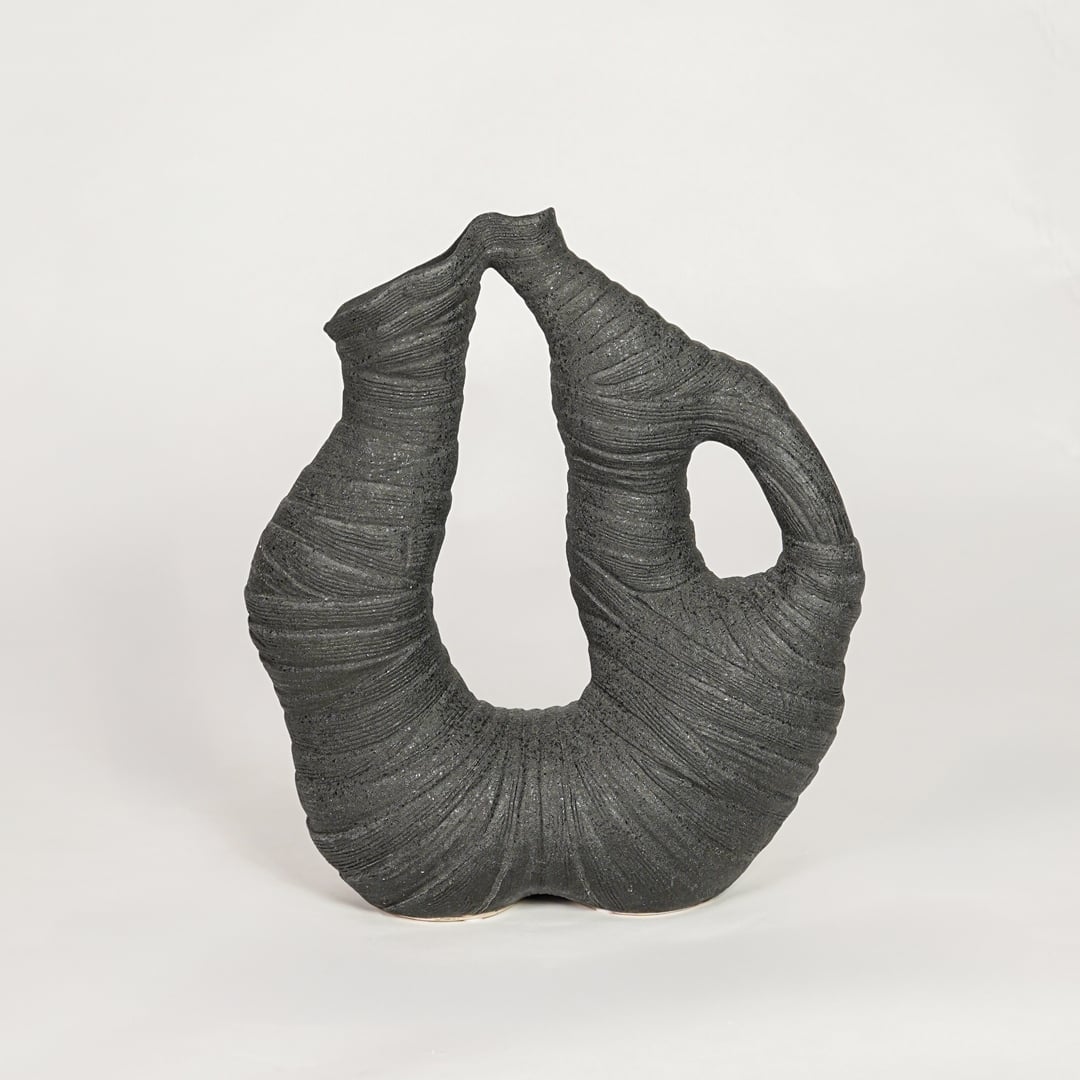 Unique black abstract sculptural vase for artistic home decor and modern statement piece on shelves or consoles.