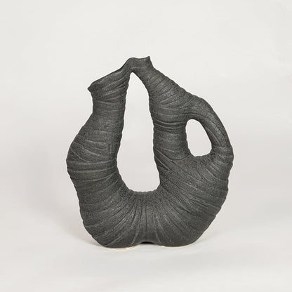 Unique black abstract sculptural vase for artistic home decor and modern statement piece on shelves or consoles.