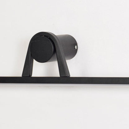 Closeup of black metal wall mounted picture light showcasing matte finish cylindrical base and minimalist linear bar.