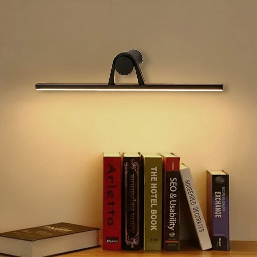 Modern black metal picture light mounted above wall artwork enhancing living room decor with sleek linear illumination.