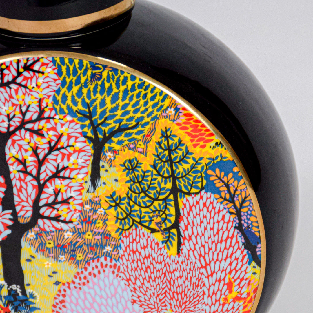 Closeup of round ceramic decorative jar with colorful tree artwork showcasing premium craftsmanship and artistic detailing.