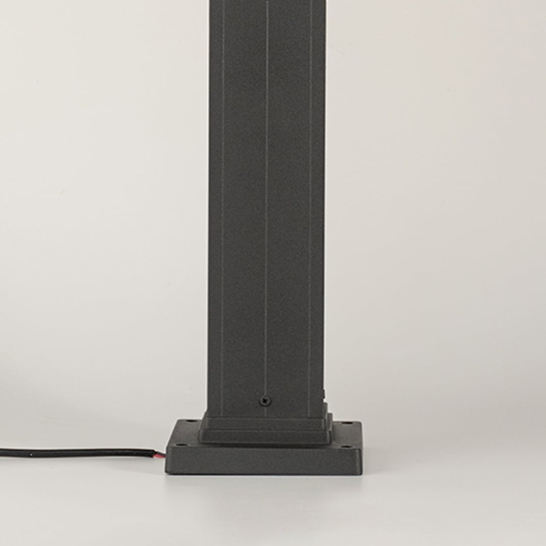 Detailed close view of the ribbed glass lantern top with the light on revealing warm illumination and the refined structure of the outdoor lamp pillar.