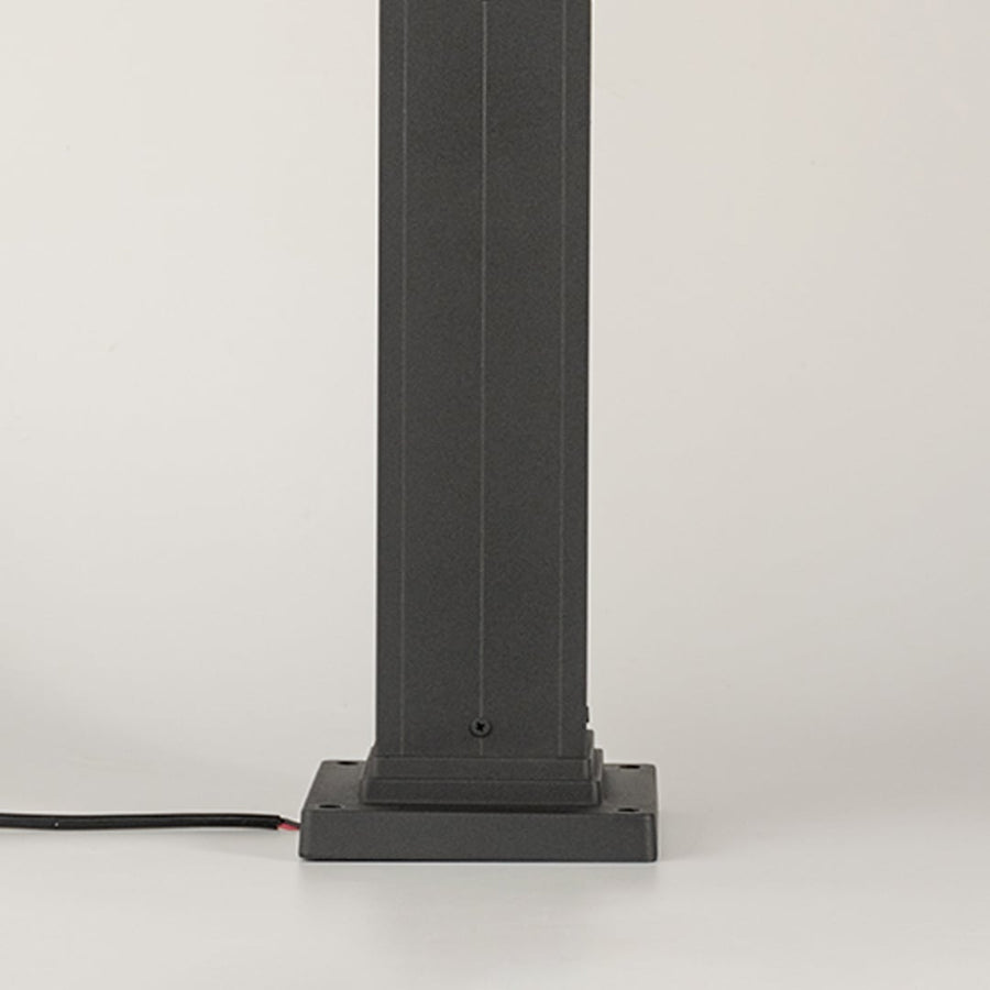 Detailed close view of the ribbed glass lantern top with the light on revealing warm illumination and the refined structure of the outdoor lamp pillar.