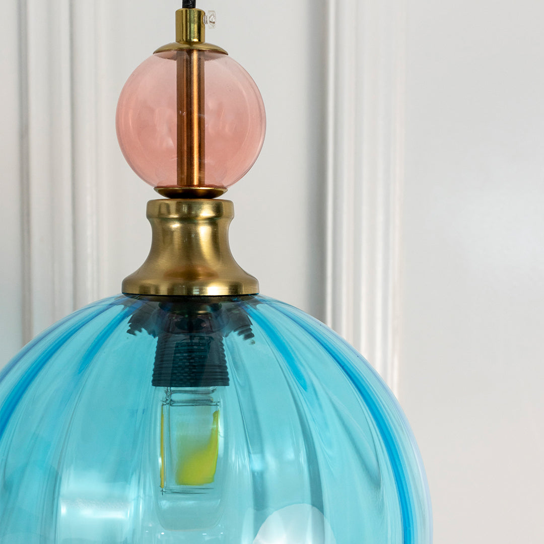 Detailed view of turquoise blue glass pendant light with brass fittings highlighting refined elegance.