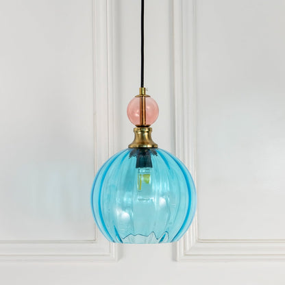 Turquoise blue glass globe pendant light with brass accents designed for stylish contemporary interiors.