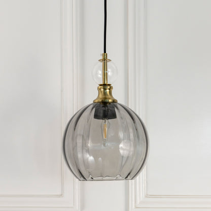 Smoky grey glass globe pendant light with brass fittings crafted for modern living and dining spaces.