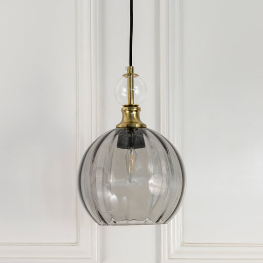Smoky grey glass globe pendant light with brass fittings crafted for modern living and dining spaces.