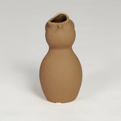 Brown ceramic sculpted vase with smooth organic silhouette isolated on clean white background for modern decor styling.