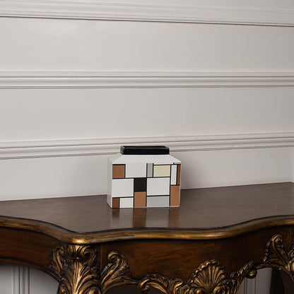 Contemporary ceramic vase with geometric block art placed against a white background for a clear product presentation.