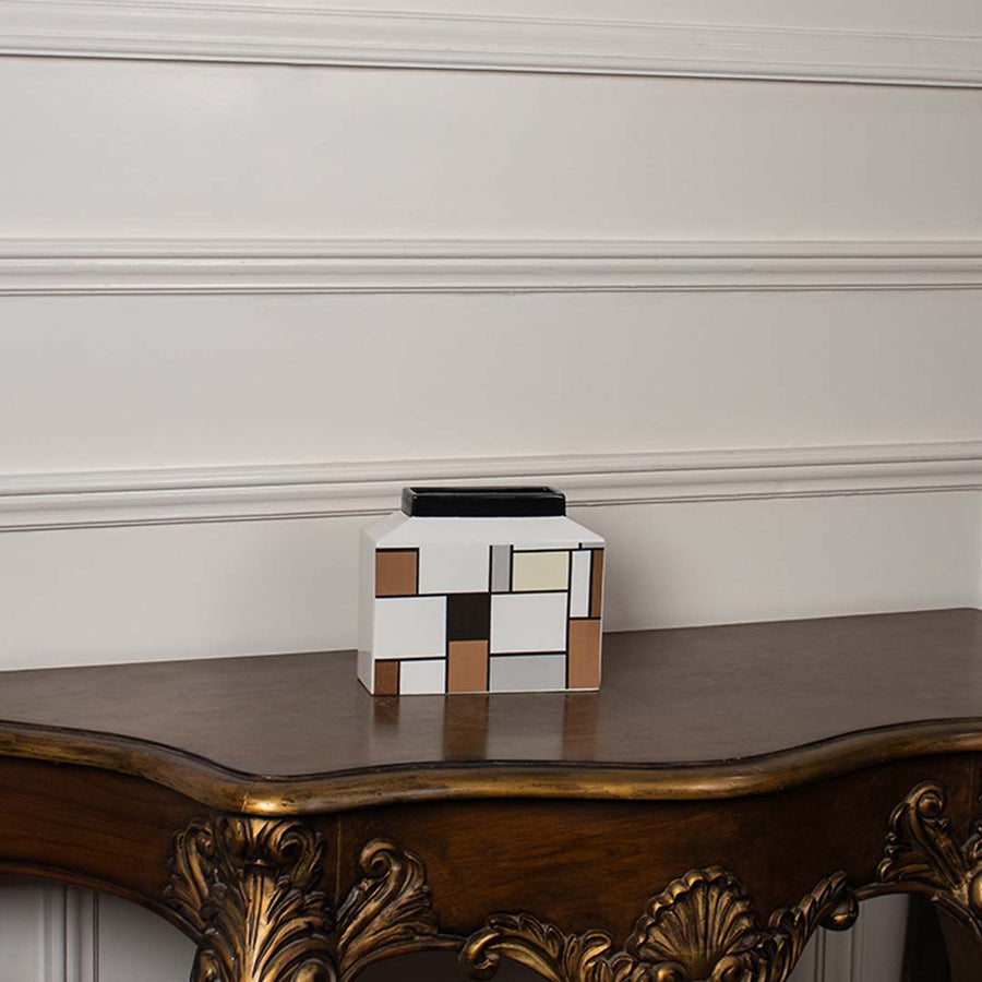 Contemporary ceramic vase with geometric block art placed against a white background for a clear product presentation.