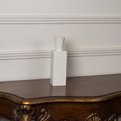 White ceramic geometric vase styled on a vintage wooden console table for elegant modern home decor arrangements.
