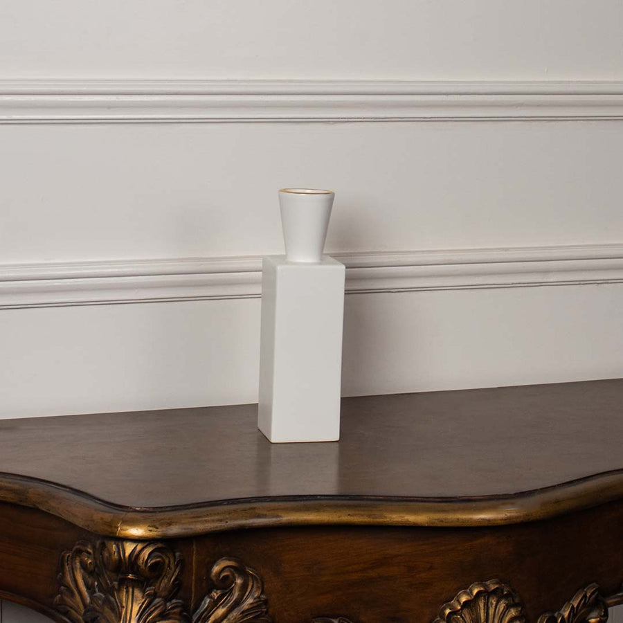 White ceramic geometric vase styled on a vintage wooden console table for elegant modern home decor arrangements.
