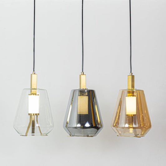 A grouped display of the pendant lights with warm illumination showing multiple glass shades glowing softly and highlighting their gold detailing with lights on.