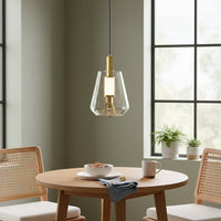 Clear glass and gold metal pendant light adding refined charm above the dining table in modern spaces.