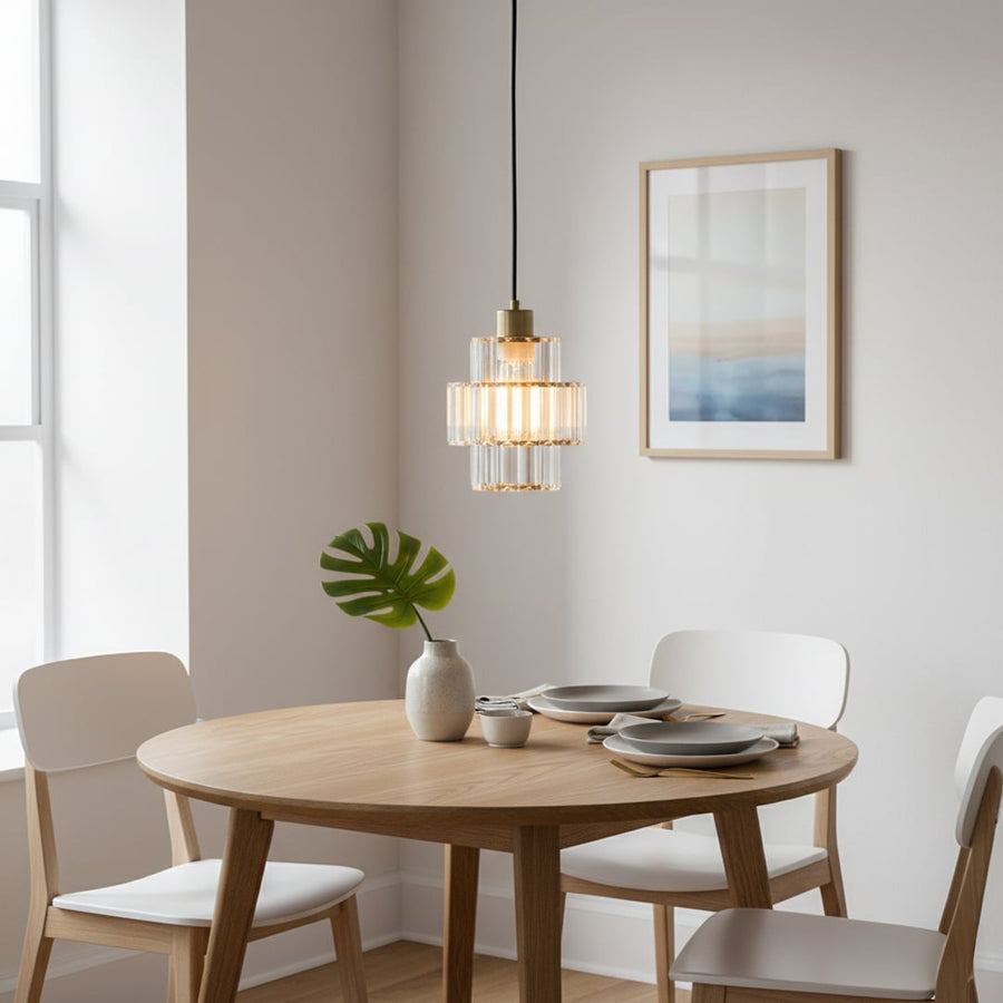 Crystal and gold metal pendant light adding warm elegance above the dining table in modern interiors.