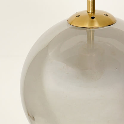 Clear glass globe pendant light with gold metal accents for elegant modern ceiling lighting decor.