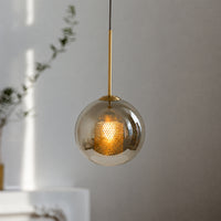 Smoked glass pendant light with gold cord enhancing cozy interiors with warm ambiance.