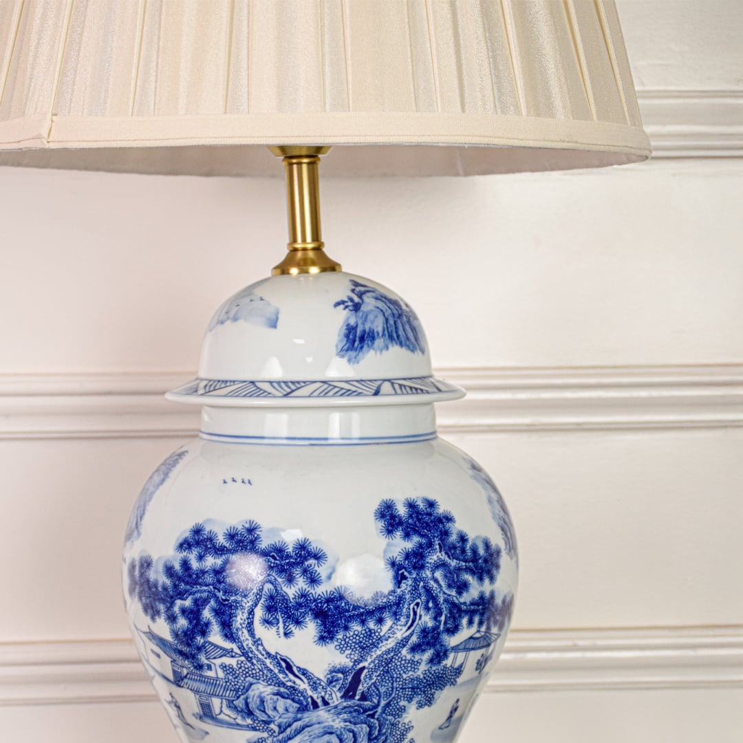 Blue and white porcelain ceramic lamp base closeup highlighting intricate traditional pattern glossy finish and brass detailing.