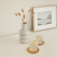 A modern sculptural vase with stacked rounded forms displayed in a minimal lifestyle setting that highlights its artistic shape and soft neutral tone.