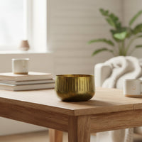 Antique brass finish bowl on wooden table for elegant modern home decor and sophisticated living room interior accents.