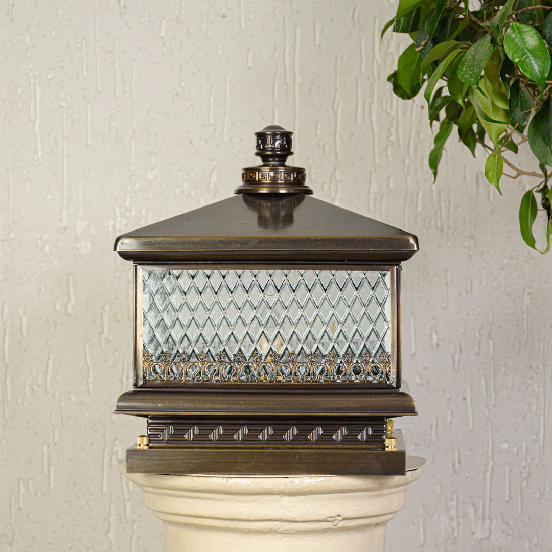 Classic outdoor pillar light with decorative glass panels mounted on exterior wall or column ideal for porch or garden lighting.