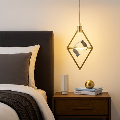Pendant light with golden diamond frame and crystal centerpiece glowing beside bed in modern bedroom decor.