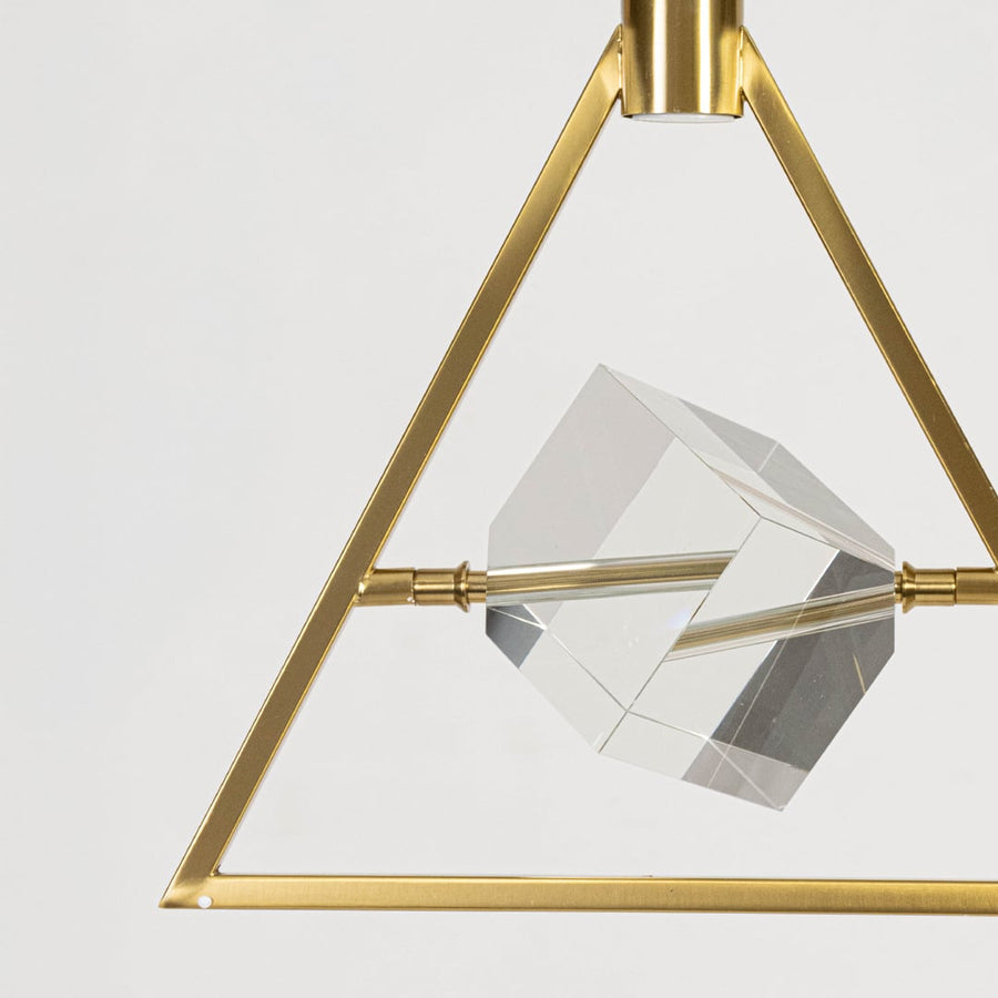 Closeup of pendant light with golden triangular frame and crystal centerpiece modern ceiling lamp decor.