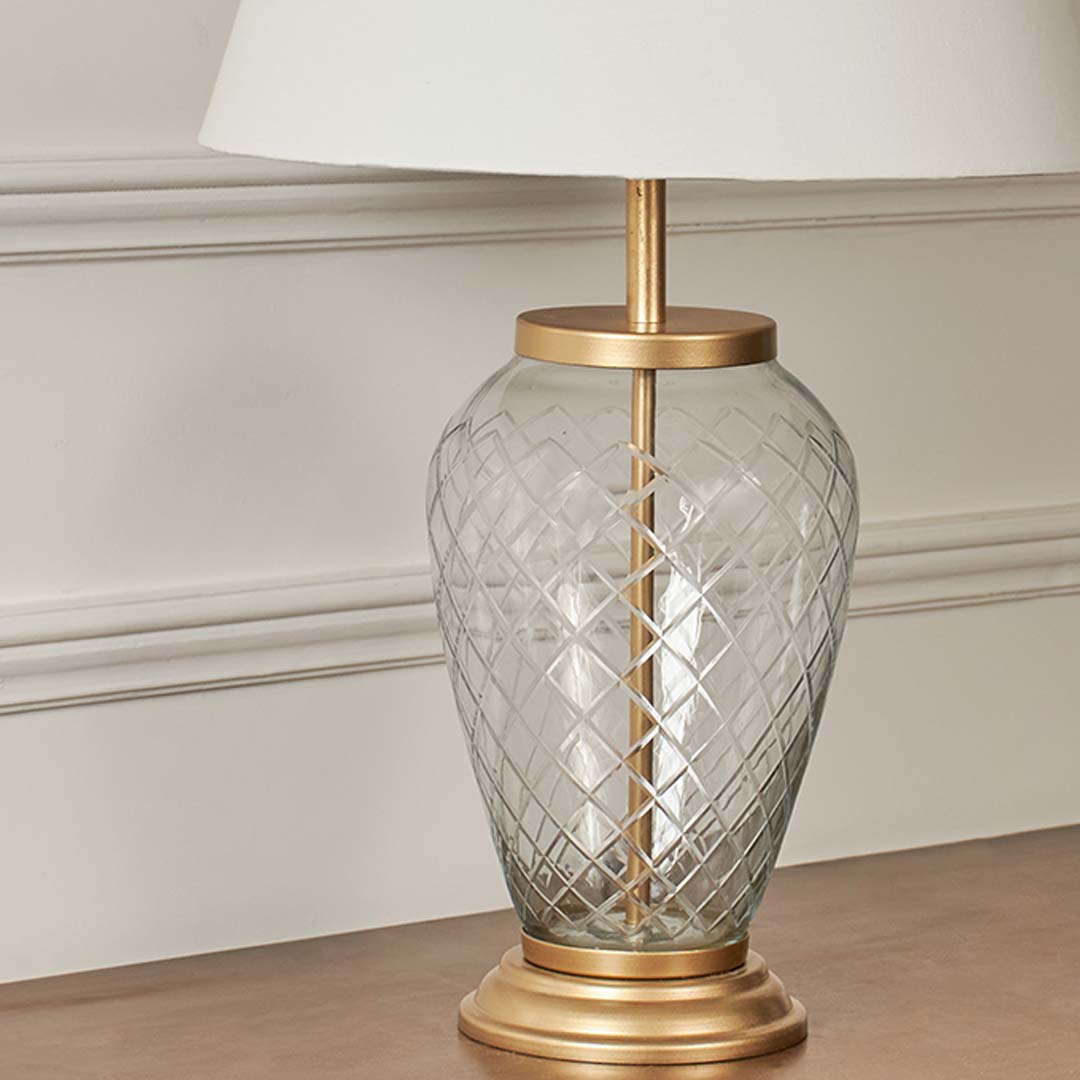 Closeup of tall floor lamp with slim chrome stand and fabric lampshade – modern minimalist design.