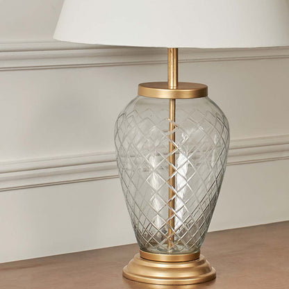 Closeup of tall floor lamp with slim chrome stand and fabric lampshade – modern minimalist design.
