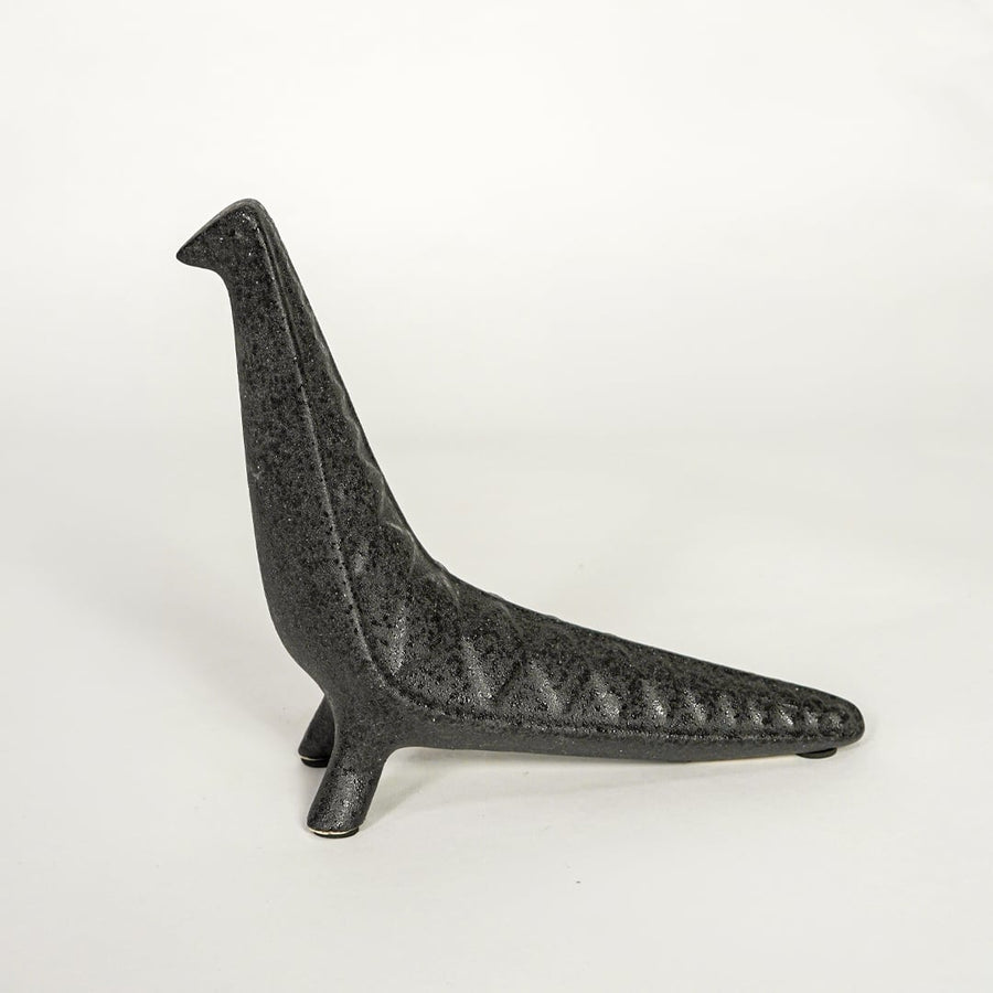 Modern dark grey ceramic decorative animal figurine with elongated body isolated on white background.