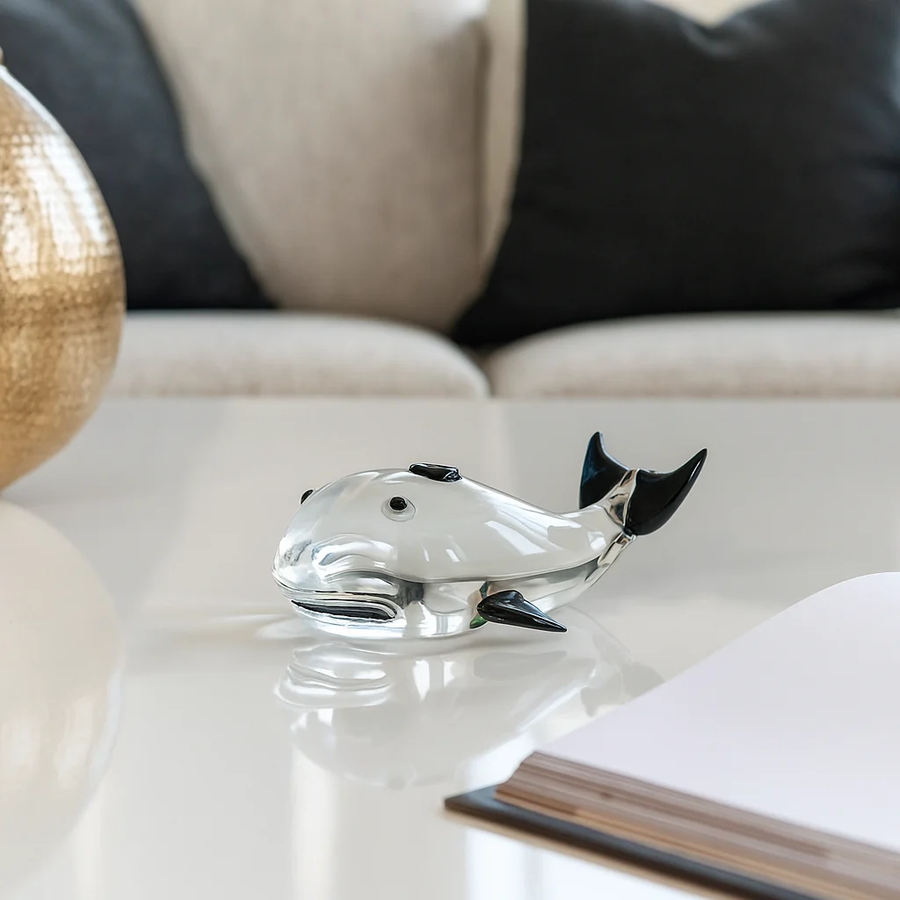 Clear glass fish decor accent placed on white table for elegant modern living room decor styling ideas.