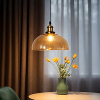 Amber glass dome pendant light above side table adding warm ambient lighting and modern elegance to home decor.