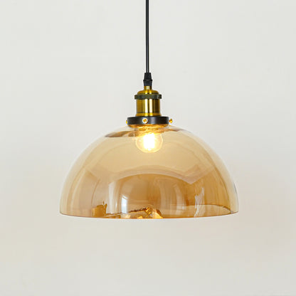 Amber glass dome pendant light with brass metal holder and modern design for elegant ceiling lighting decor.
