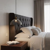 Smoked glass dome pendant light beside bed adding warm ambient lighting and modern elegance to bedroom decor.