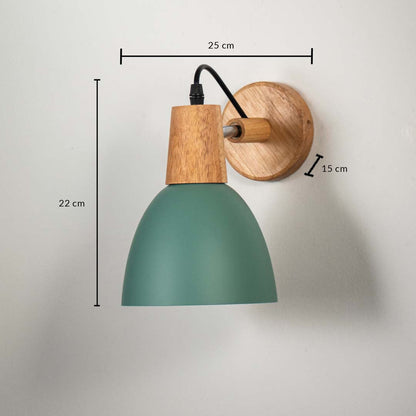 Wall lamp with matte green shade wooden base and black cord shown with size 22 cm height 25 cm width and 15 cm depth.
