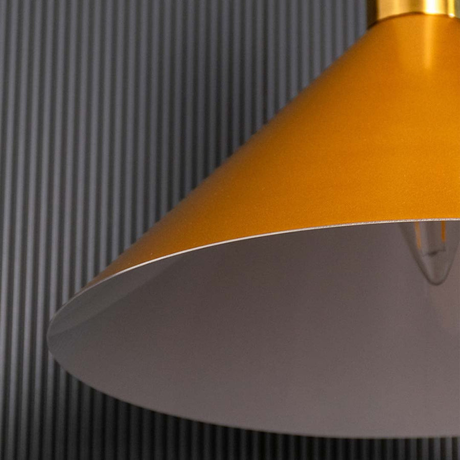A closeup view of the gold metal pendant light showing the smooth metallic surface and tapered design ideal for modern luxury interiors.