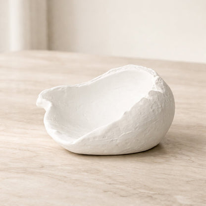 White ceramic decorative bowl placed on wooden table modern centerpiece decor for living room console styling.