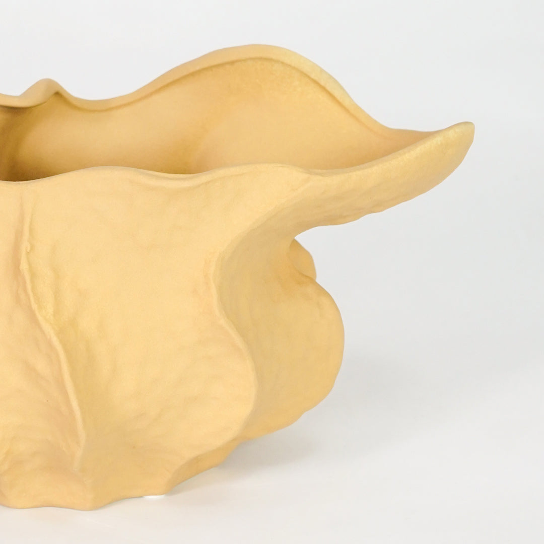 Closeup image of yellow ceramic abstract decor bowl for modern tabletop styling with smooth matte artistic finish.