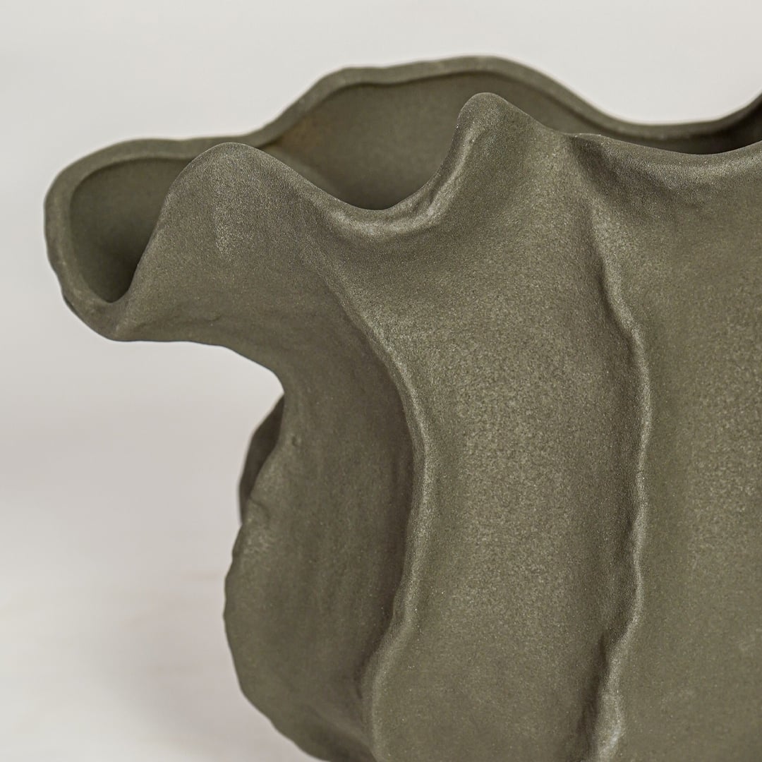 Detailed closeup of black doof table ceramic vase highlighting sculpted curves and textured matte surface.