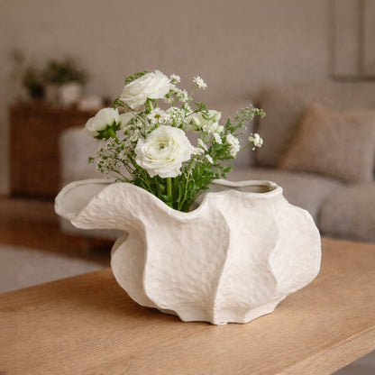 White ceramic abstract decorative bowl styled with fresh flowers enhancing soft and sophisticated home decor setting.