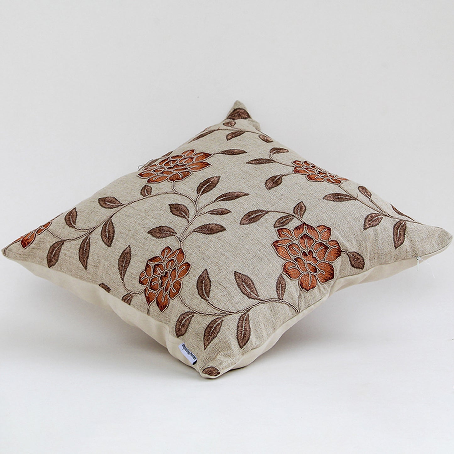 Side view of beige cushion cover with intricate floral pattern soft fabric feel and classic decorative cushion appearance.